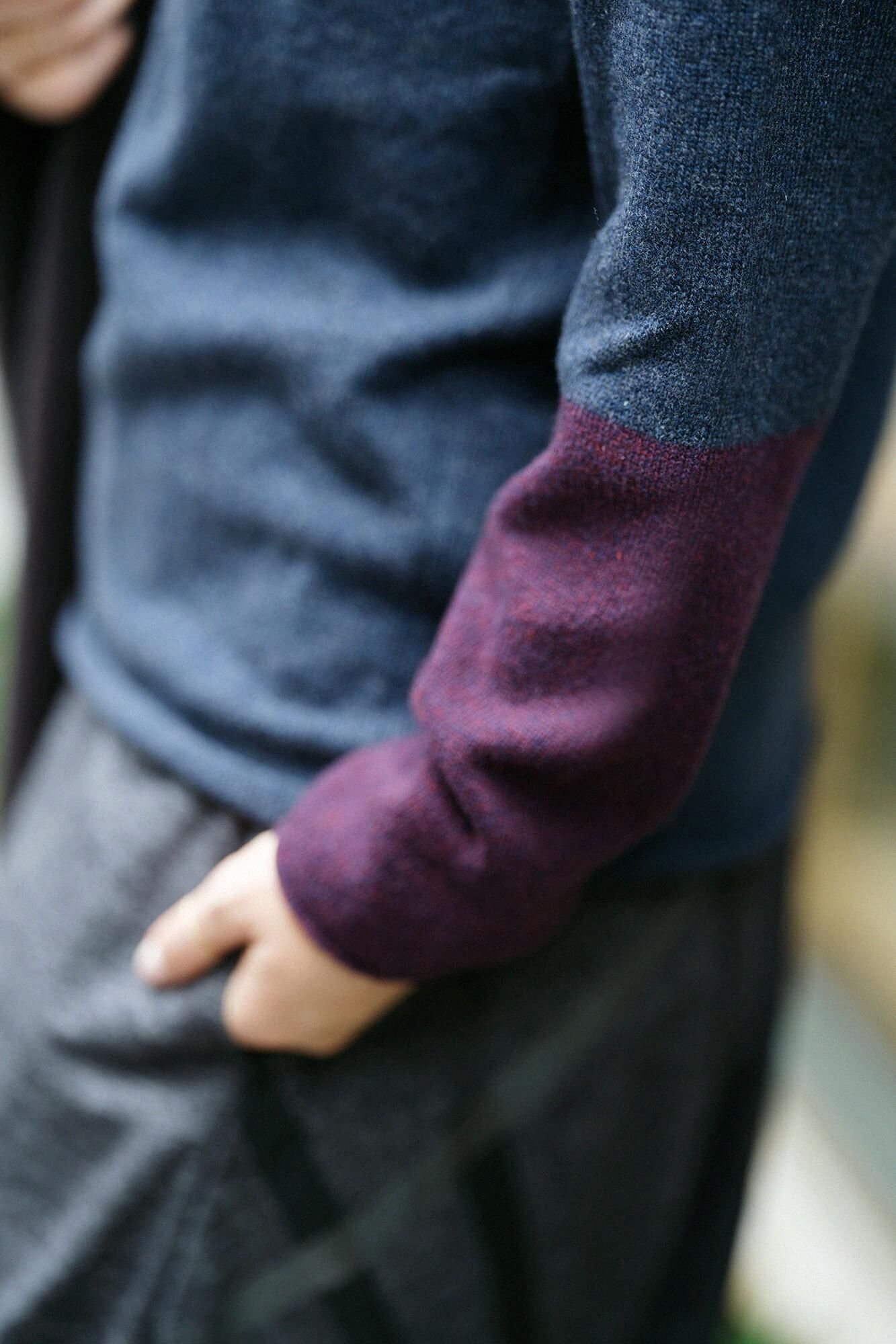 Waschbarer Wollstrick mit unterschiedlichen Kragenärmeln / blaubraun x granatapfelfarben